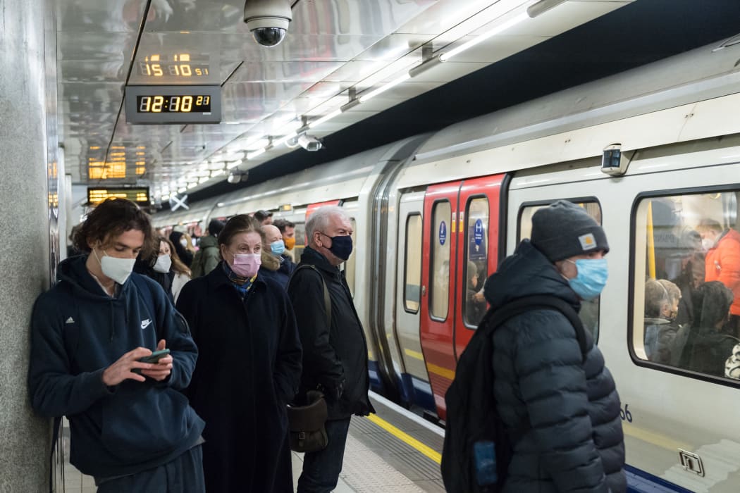 Commuters wearing face masks travel on the London Underground.