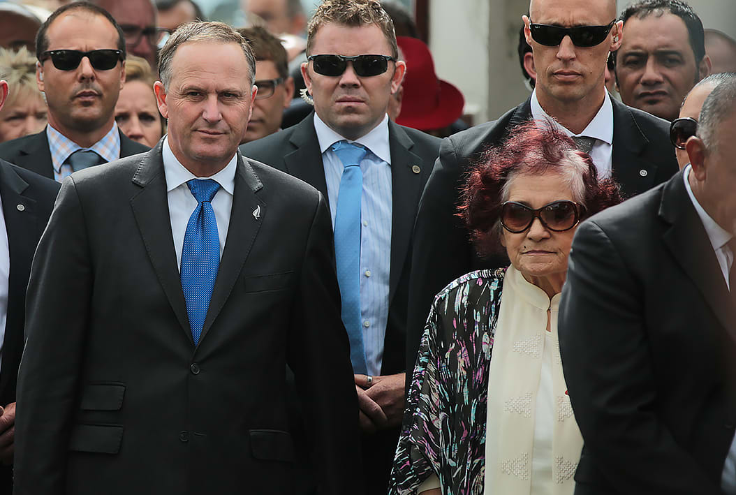 John Key is escorted onto Te Tii Marae at Waitangi by Ngapuhi kuia Titewhai Harawira (R) and Ngati Whatua leader Naida Glavish.