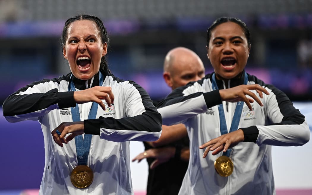 New Zealand's players perform a haka as they celebrate with their gold medals during the victory ceremony following the women's gold medal rugby sevens match between New Zealand and Canada during the Paris 2024 Olympic Games at the Stade de France in Saint-Denis on July 30, 2024. (Photo by CARL DE SOUZA / AFP)