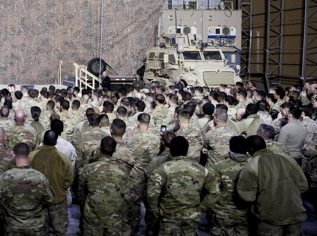 FILE - In this Dec. 26, 2018, file photo, troops listen to President Donald Trump speak at a hangar rally at Al Asad Air Base, Iraq.