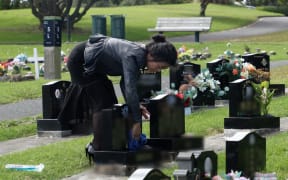 Carina Zhong wiping the headstones of a passed family member.