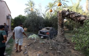 Libyans gather at the site of where a mortar shell landed in the capital Tripoli on August 30, 2018.