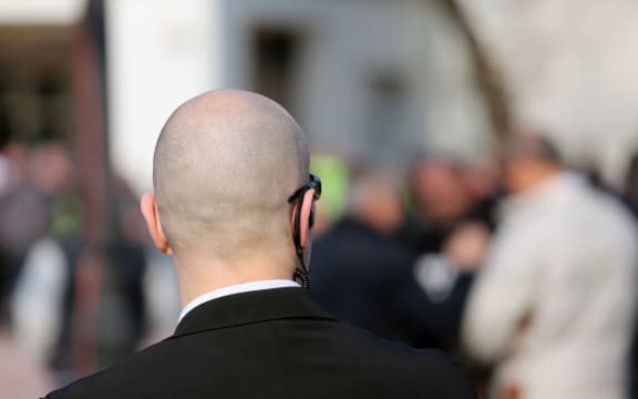 security guard with dark glasses and a radio headset to control people