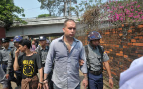 New Zealand bar manager Philip Blackwood, centre, is escorted by police as he arrives at a court for a hearing in Yangon on 17 March 2015.