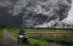 A man looks at a pyroclastic flow during the eruption of Mount Semeru in Lumajang, East Java, on 19 November, 2025.