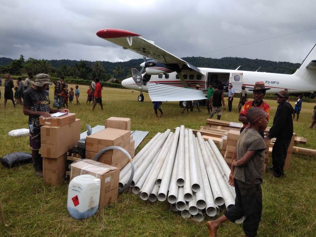 MAF unloading Building supplies at Fogumaiu with Michael Duncalfe supervising the process