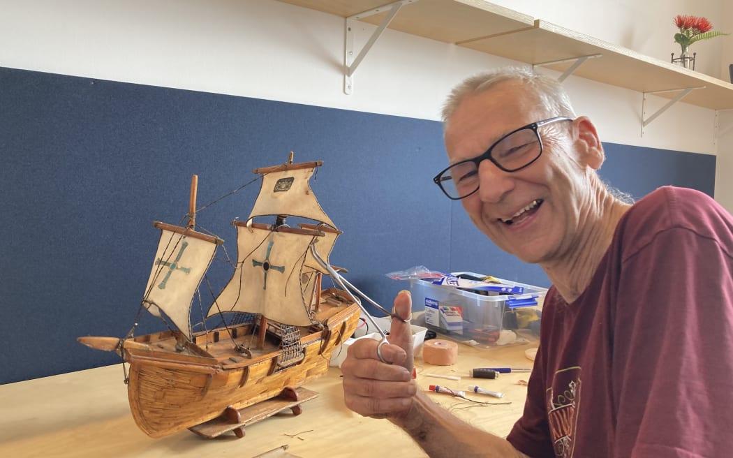 Repair cafe volunteer Pete is fixing a model sailing ship made of matchsticks.