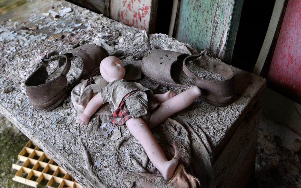 A doll and shoes lay on a bench in a nursery school of the "ghost town" of Pripyat.
