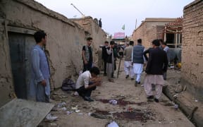 Residents gather near the site following the suicide bombing.