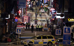Police work at the scene in to the night after a truck slammed into a crowd of people outside a busy department store in central Stockholm.