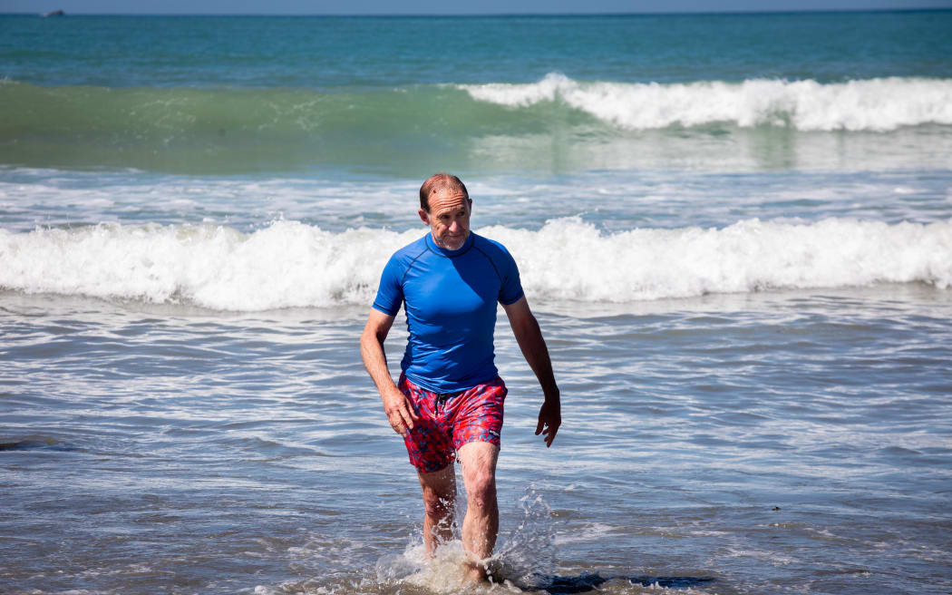 Wellington mayor Andrew Little swims at Lyall Bay after announcing the lifting of a swimming ban.