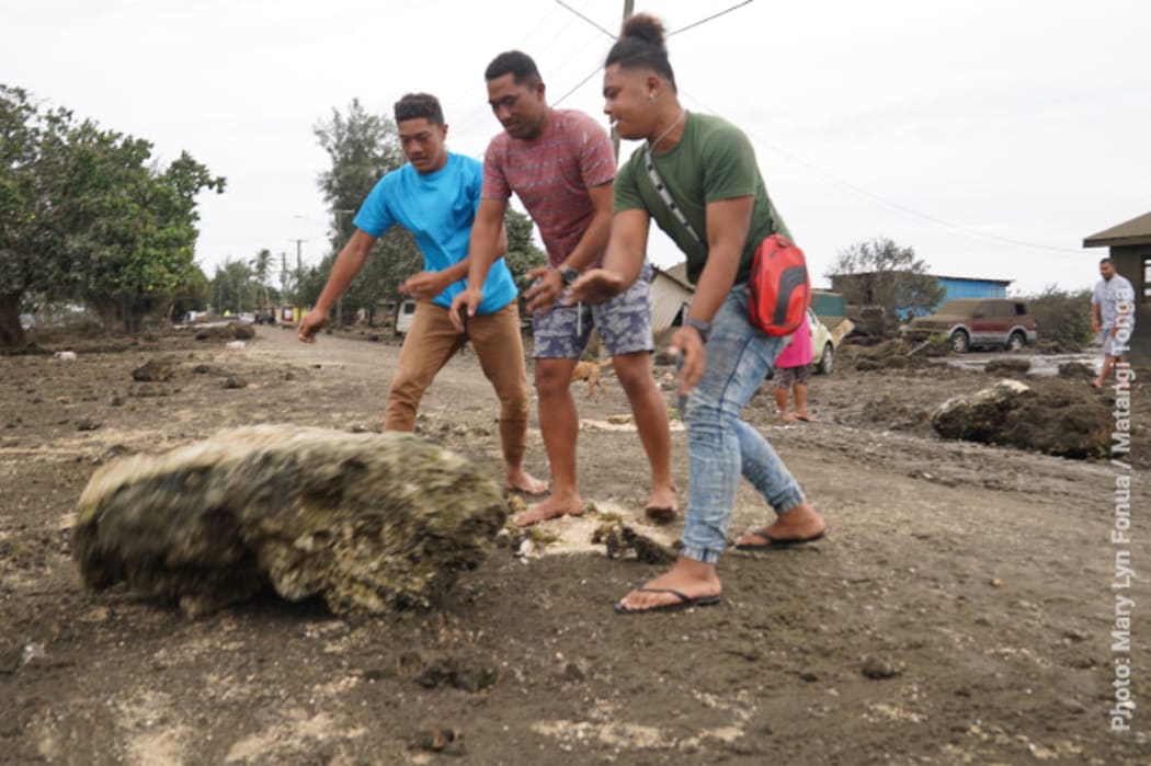 Residents at Patangata Settlement in the capital Nukua'lofa clear boulders from the seafront road.