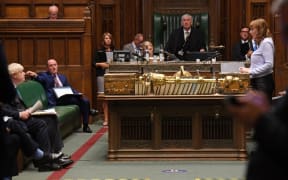 A handout photograph released by the UK Parliament shows Britain's Prime Minister Boris Johnson (L) listening as Britain's main opposition Labour Party deputy leader Angela Rayner speaks during Prime Minister's Questions (PMQs).