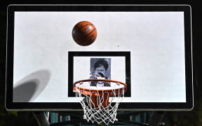 This picture taken on October 15, 2019, shows a basketball thrown by a protester before it hits a poster of Hong Kong Chief Executive Carrie Lam at the Southorn Playground in Hong Kong.