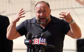 WATERBURY, CONNECTICUT - SEPTEMBER 21: InfoWars founder Alex Jones speaks to the media outside Waterbury Superior Court during his trial on September 21, 2022 in Waterbury, Connecticut. Jones is being sued by several victims' families for causing emotional and psychological harm after they lost their children in the Sandy Hook massacre. A Texas jury last month ordered Jones to pay $49.3 million to the parents of 6-year-old Jesse Lewis, one of 26 students and teachers killed in the shooting in Newtown, Connecticut.   Joe Buglewicz/Getty Images/AFP (Photo by Joe Buglewicz / GETTY IMAGES NORTH AMERICA / Getty Images via AFP)