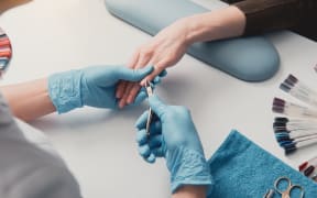 Nail artist creating manicure in beauty salon
