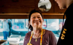 (L-R) Mom Meng glances up at her granddaughter Emrie Meng in her food truck in Lower Hutt, Wellington.