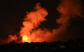 Explosions illuminate the sky during Israeli strikes on Gaza City on 10 October 10, 2023.