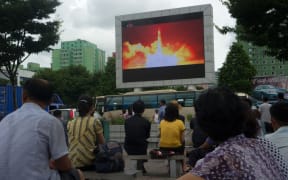 People watching as coverage of an earlier ICBM missile test is displayed on a screen in a public square in Pyongyang in July.