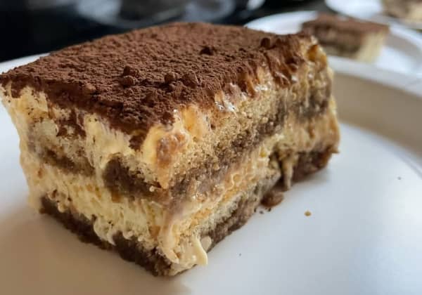 A slice of tiramisu on a white plate.
