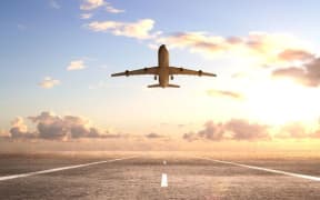 Plane above runway.