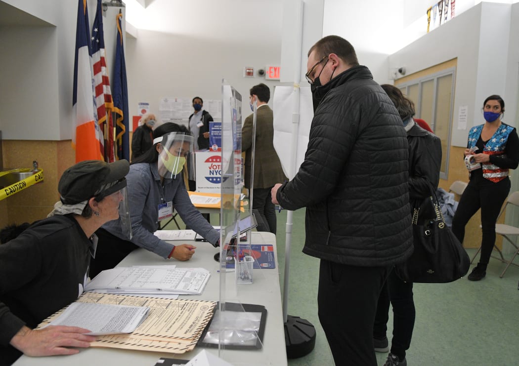 A man wearing a face mask registers for the voting at a pooling station during the Presidential election, in New York.