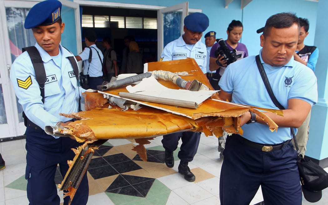 Indonesian military officers carry wreckage from AirAsia QZ8501 in Pangkalan Bun, the town with the nearest airstrip to the crash site, on 2 January.