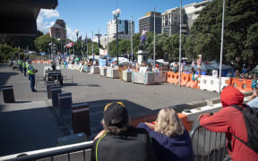 Anti-vaccine, anti-mandate protest in Wellington on Parliament grounds on 16 February 2022. Police standing on forecourt.