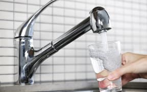 water running from a tap into a glass