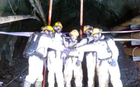 Dinghy Pattinson, Lloyd Steward, Geoff Rubbo, Leon Pigott and Luke Taylor celebrate reaching the roof fall (the black area behind them) after completing their forensics work in the last few metres.