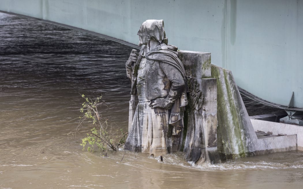 Floodwaters race past the Zouave statue at the Alma bridge on the River Seine, Paris. Floods in 1910 reached its shoulders.