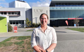 Sarah Kessans from the University of Canterbury stands in front of a University building.