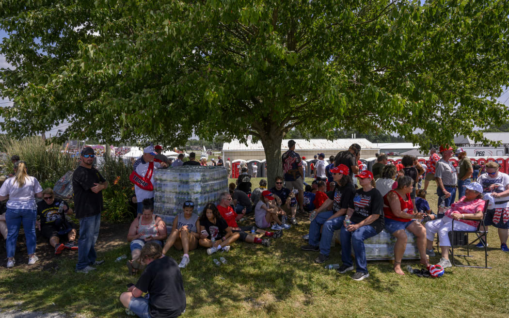 Trump supporters seeking shade while waiting in 92F degree (33C) weather for the start of a campaign rally for former US President Donald Trump at Butler Farm Show Inc on 13 July, 2024 in Butler, Pennsylvania.
