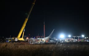 Firefighters and rescue personnel work near the scene where a Jeju Air Boeing 737-800 series aircraft crashed and burst into flames at Muan International Airport in South Jeolla Province, some 288 kilometres southwest of Seoul on December 29, 2024. - A Jeju Air plane carrying 181 people from Thailand to South Korea crashed on arrival, smashing into a barrier and bursting into flames, leaving all but two feared dead. (Photo by Jung Yeon-je / AFP)