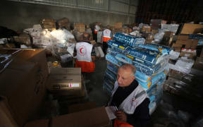 Red Crescent workers sort aid before being distributed to Palestinians, as the conflict between Israel and Palestinian Islamist group Hamas continues, in Khan Younis in the southern Gaza Strip, October 23, 2023.  (Photo by Majdi Fathi/NurPhoto) (Photo by MAJDI FATHI / NurPhoto / NurPhoto via AFP)
