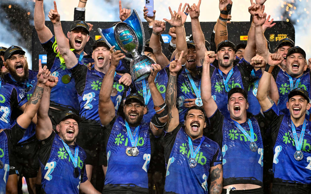 Blues captain Patrick Tuipulotu holds up the trophy as the Blues team celebrate winning the Super Rugby Pacific final.