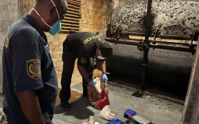 About 45 pounds of cocaine was incinerated on North Loi Island, Kwajalein Atoll by Marshall Islands Police Department Sgt. Carlson Clarance, left, and Captain Banner Korwan. Photo: Office of National Security, Marshall Islands.