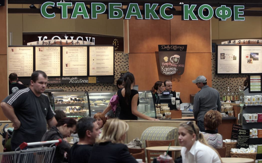 Customers buy and drink coffee on opening day of Russia's first Starbucks in Moscow, 06 September 2007. Starbucks is hoping cash in on the Russian market despite the fact that several Russian coffee house chains are already widespread.        AFP PHOTO / NATALIA KOLESNIKOVA (Photo by NATALIA KOLESNIKOVA / AFP)