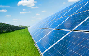 Solar panels, grass and and blue sky.