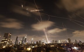 Israeli air defence systems are activated to intercept Iranian missiles over the Israeli city of Tel Aviv early on June 18, 2025. Israel and Iran exchanged fire again on June 17, the fifth day of strikes in their most intense confrontation in history, fuelling fears of a drawn-out conflict that could engulf the Middle East. (Photo by Menahem Kahana / AFP)