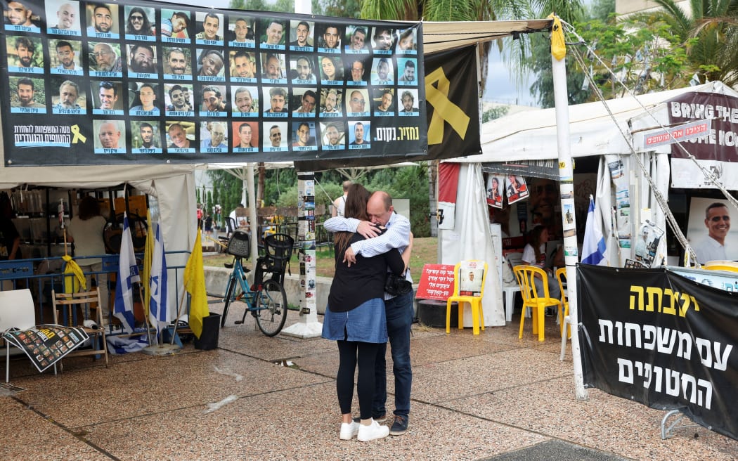 People hug in "Hostages Square" in Tel Aviv, Israel, on 8 October.