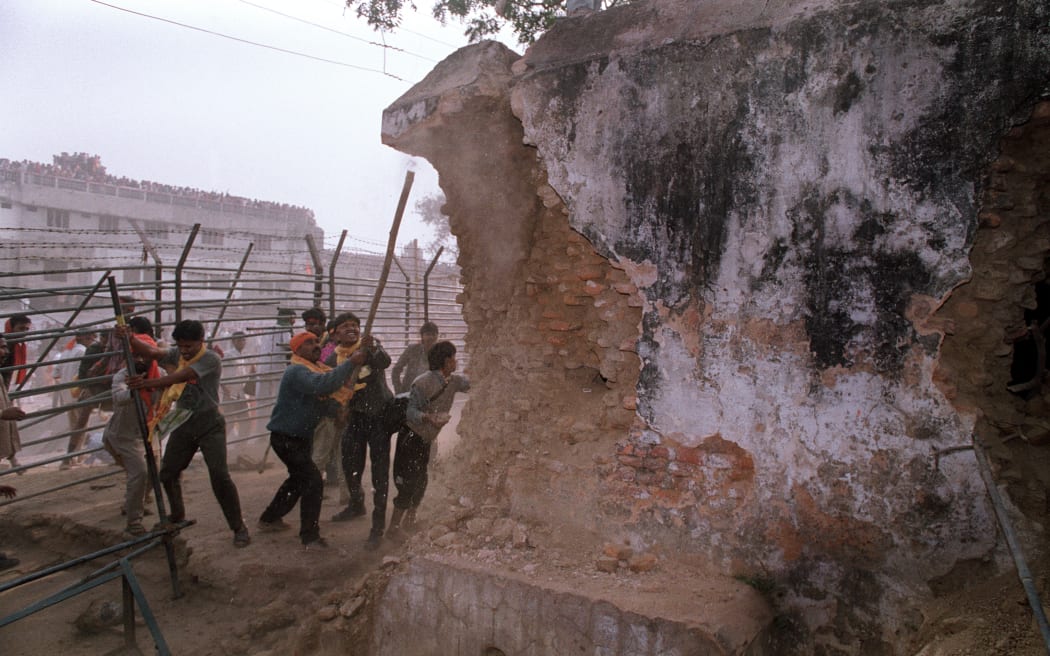 (FILES) Hindu fundamentalists attack the wall of the 16th century Babri Masjid Mosque with iron rods at a disputed holy site in the city of Ayodhya on December 6, 1992. India's Prime Minister Narendra Modi will on January 22, 2024 inaugurate a temple that embodies the triumph of his muscular Hindu nationalist politics, in an unofficial start to his re-election campaign this year. The 50-metre (160-foot) tall house of worship for the deity Ram was built on grounds where a mosque stood for centuries before it was torn down by Hindu zealots incited by members of Modi's party. (Photo by Douglas E. CURRAN / AFP)