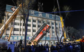 Chinese rescuers watching as a bus is lifted out after a road collapse in Xining in China's northwestern Qinghai province on 13 January, 2020.