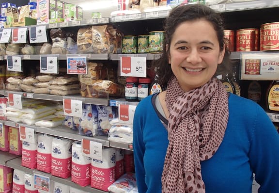 Lisa Te Morenga stands in front of shelves of sugar in a supermarket.