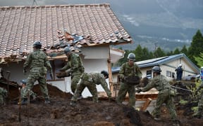 Troops from's Japan Ground Self-Defense Force search for survivors at a landslide site