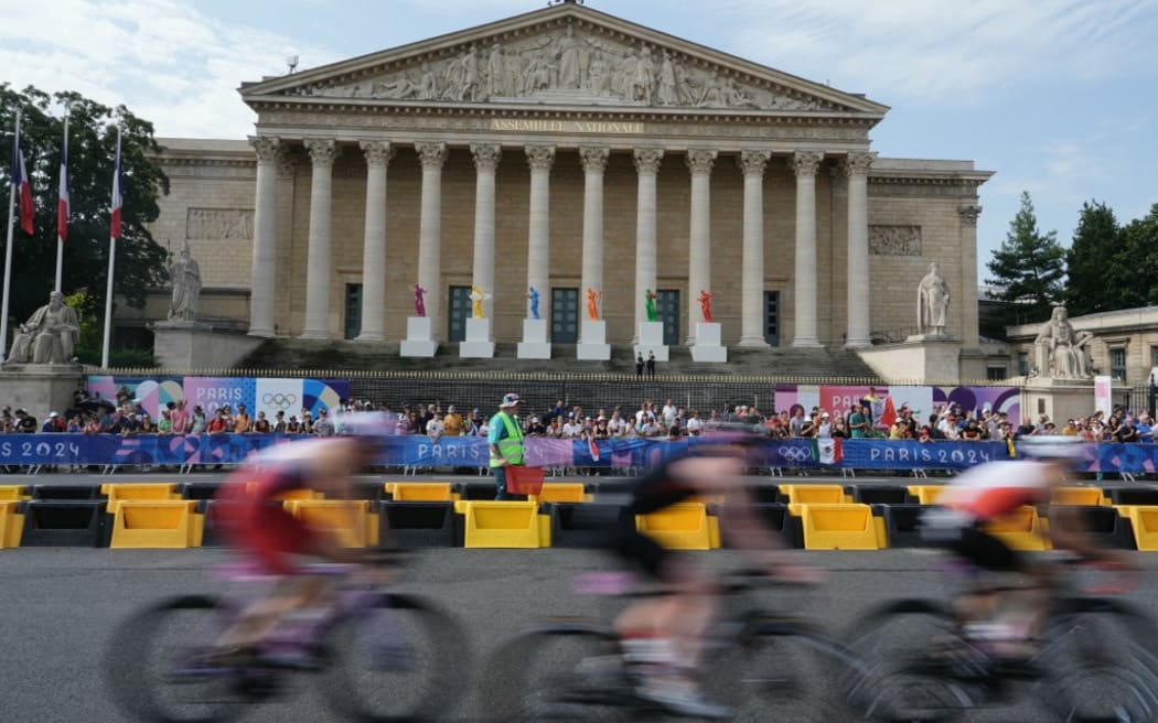 Athletes compete in the cycling stage during the men's individual triathlon at the Paris 2024 Olympic Games in central Paris on July 31, 2024. (Photo by Dimitar DILKOFF / AFP)