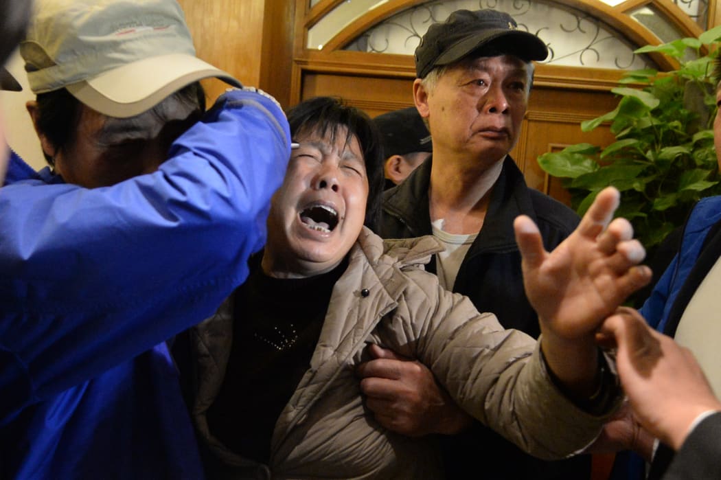 A relative of a passenger on Malaysian Airlines flight MH370 cries after hearing the plane crashed into the Indian Ocean.