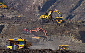 Excavators and trucks at a coal mine in South Kalimantan, Indonesia.