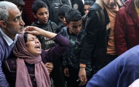 Relatives are mourning as they pray over the bodies of victims killed by Israeli bombing in Deir el-Balah, in the central Gaza Strip, on December 4, 2023. Israel is expanding its offensive against Hamas militants in the besieged Gaza, while international concern is deepening over the increasing civilian death toll in a war that was sparked by the attacks on October 7. (Photo by Majdi Fathi/NurPhoto) (Photo by MAJDI FATHI / NurPhoto / NurPhoto via AFP)