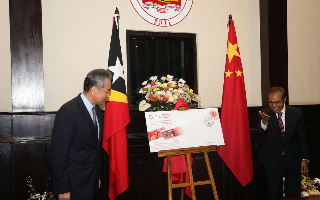 Chinese Foreign Minister Wang Yi (L) presents East Timor's Prime Minister Taur Matan Ruak a souvenir during a meeting in Dili on June 3, 2022. (Photo by VALENTINO DARIEL SOUSA / AFP)